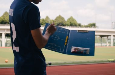 A man planning football tactics on a clipboard