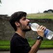 Man drinking from a water bottle during exercise