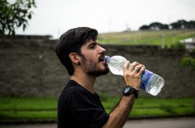 Man drinking from a water bottle during exercise