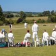 Village cricket mach in progress with spectators watching on