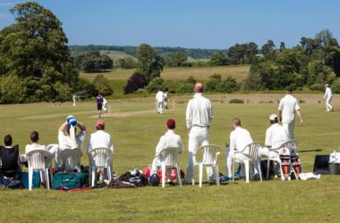 Village cricket mach in progress with spectators watching on